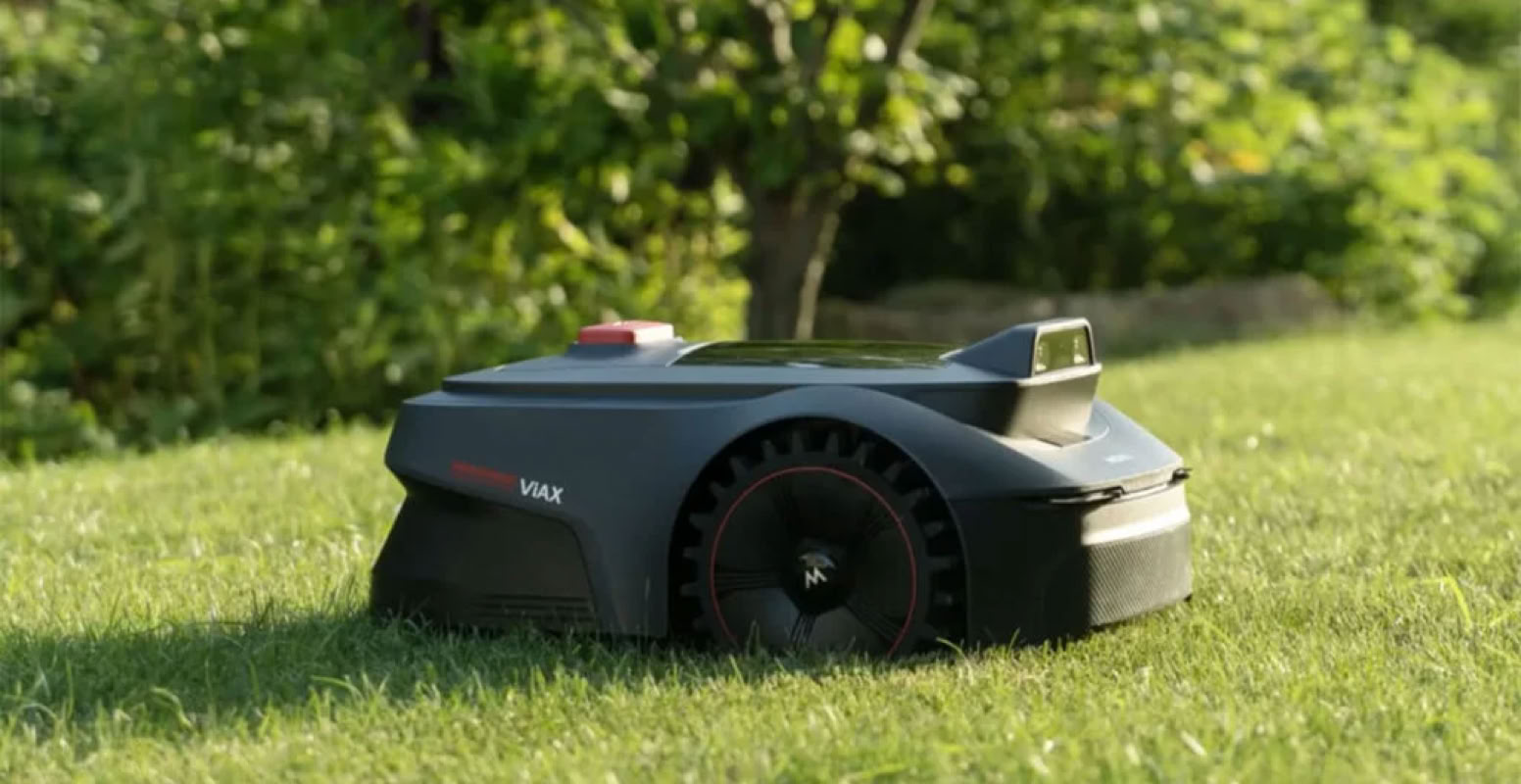 Tondeuse robotique MOVA sur une pelouse verte avec des arbres en arrière-plan.